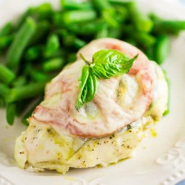 Quick and easy Baked Caprese Chicken features cheesy chicken breast with basil pesto, basil leaves, and a slice of fresh tomato for a fresh and healthy weeknight dinner! 